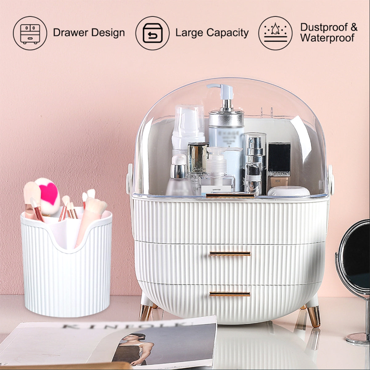 A white ribbed cosmetic organizer with a clear dome lid and three drawers, shown on a tabletop with beauty products inside. A matching white cup sits to the left, and a small round mirror is partially visible on the right.