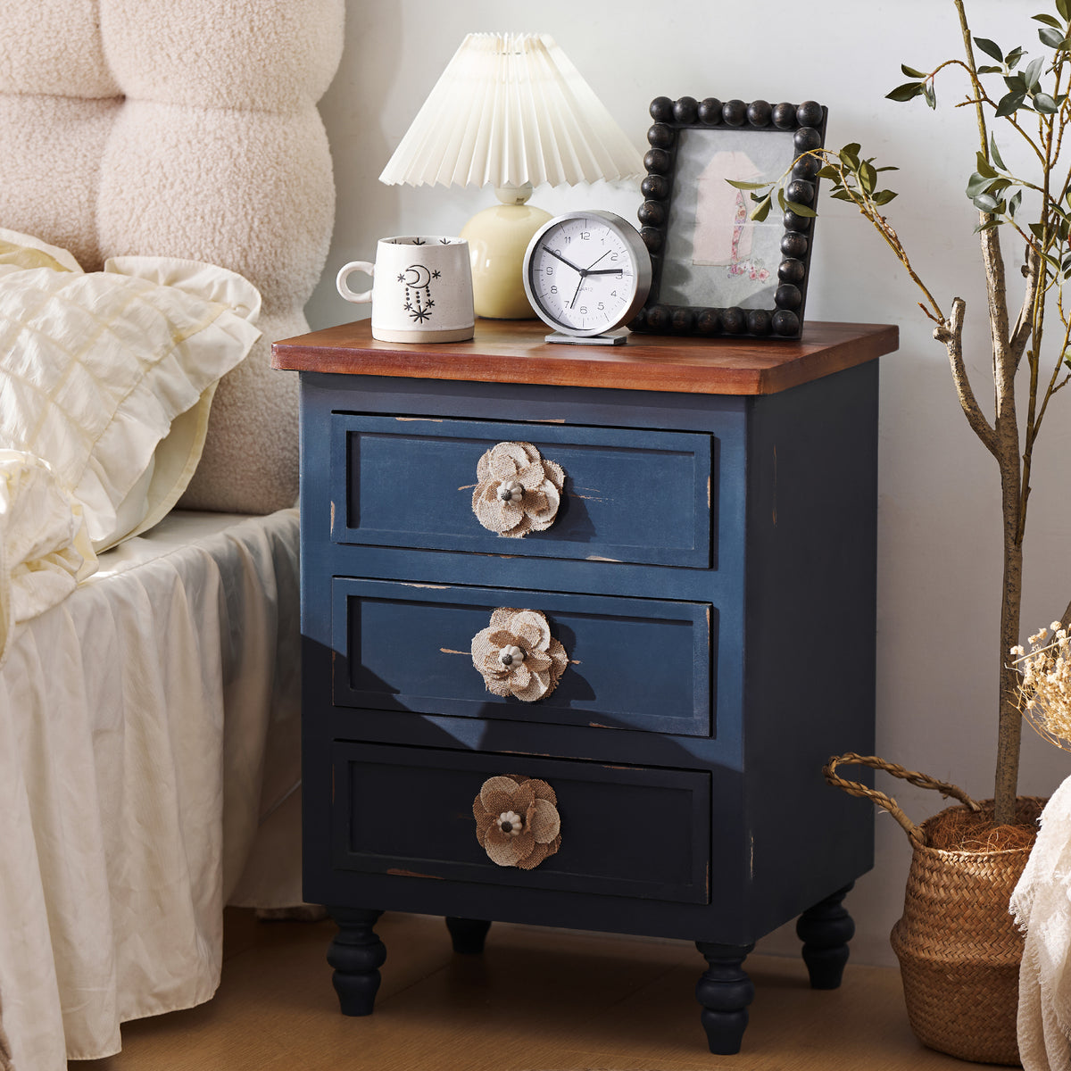 Vintage blue three-drawer nightstand with floral knobs, a walnut top and turned legs