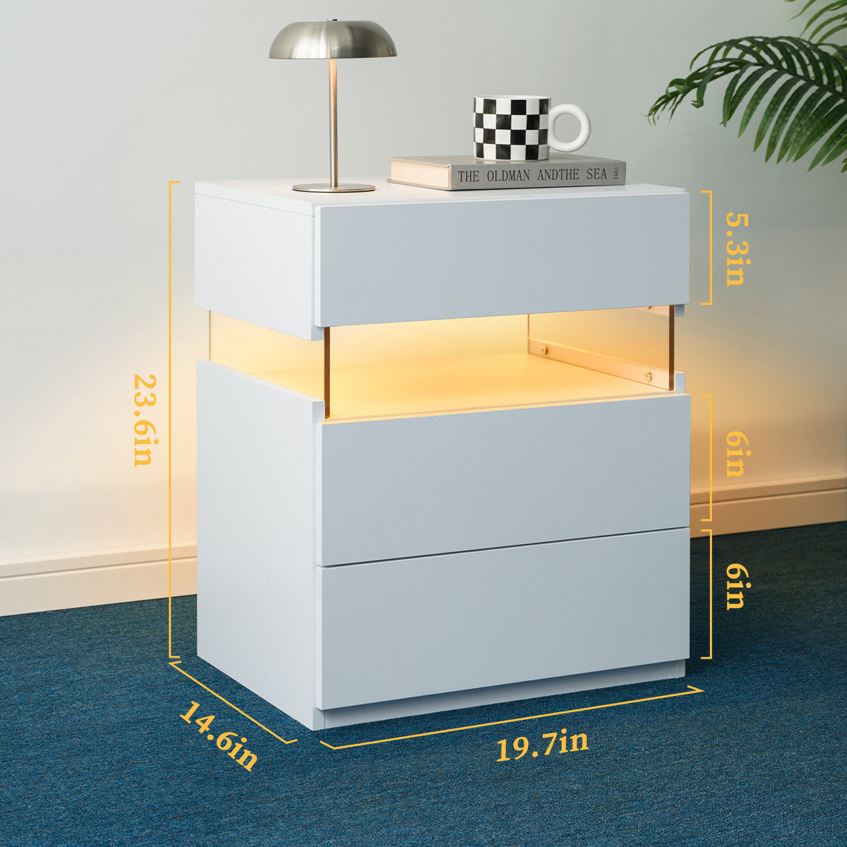 White nightstand with dimensions displayed, featuring a lamp and books on top.