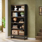 Dark wooden bookshelf with decorative items against a green wall.