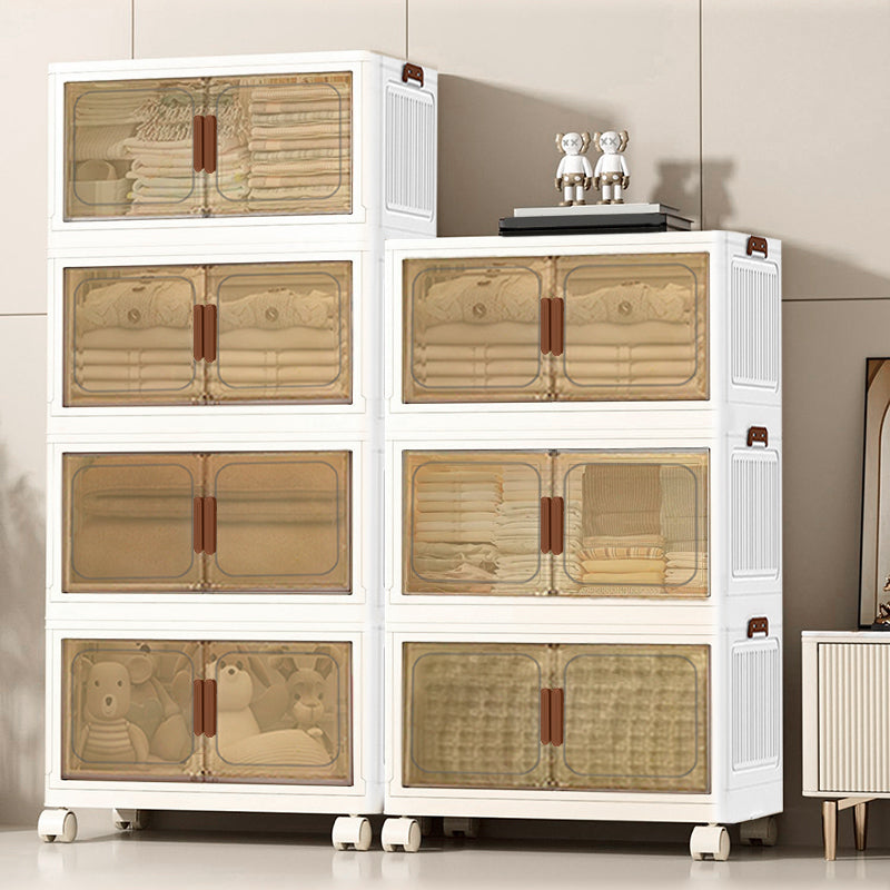 A set of six white plastic storage drawers with translucent beige-tinted doors and brown handles, shown filled with folded linens and toys in a clean indoor room setting.