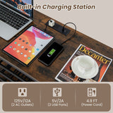 Desk setup with laptop, tablet, phone, and charging station on a wooden surface.