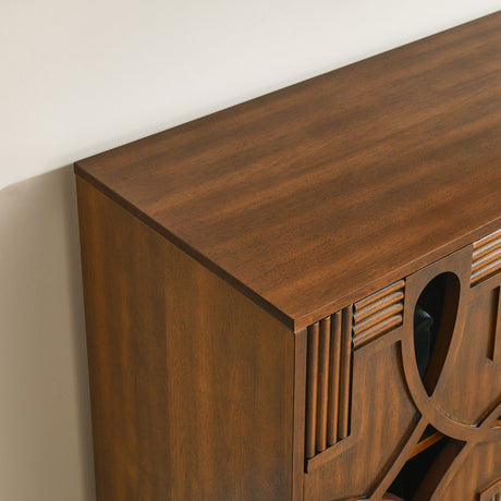 Close-up of a wooden console table with decorative carvings against a beige wall.