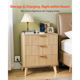 Wooden nightstand with charging station next to a bed in a bedroom setting.